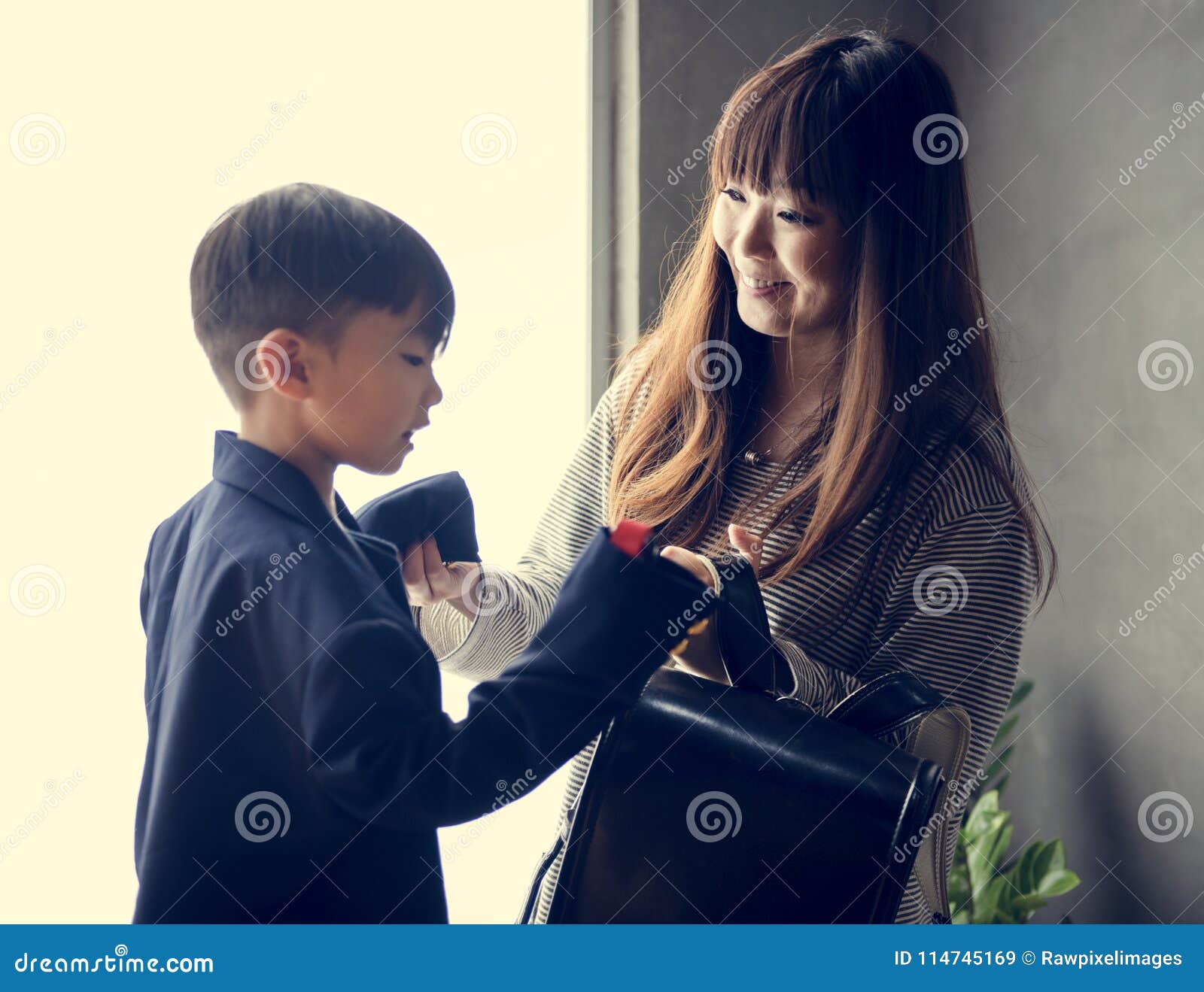 Japanese mother and baby son (wearing a blue hat and jacket) lookiing at each other