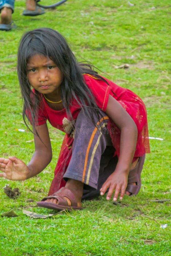 Young dirty Indian girl listens to a village meeting