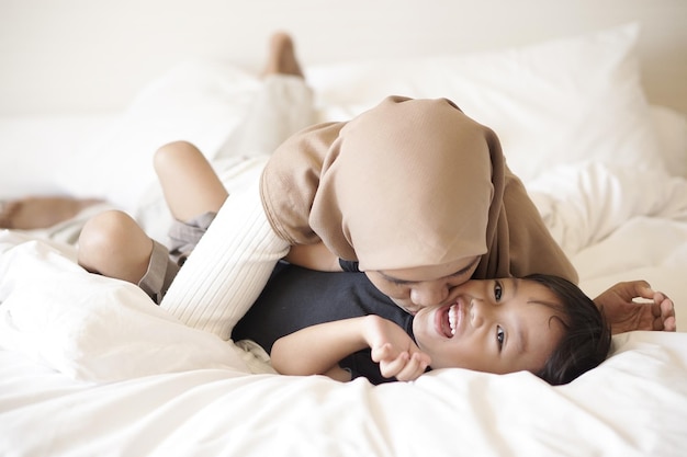 Happy family in pajamas on the bed at home. Mother, father and son.